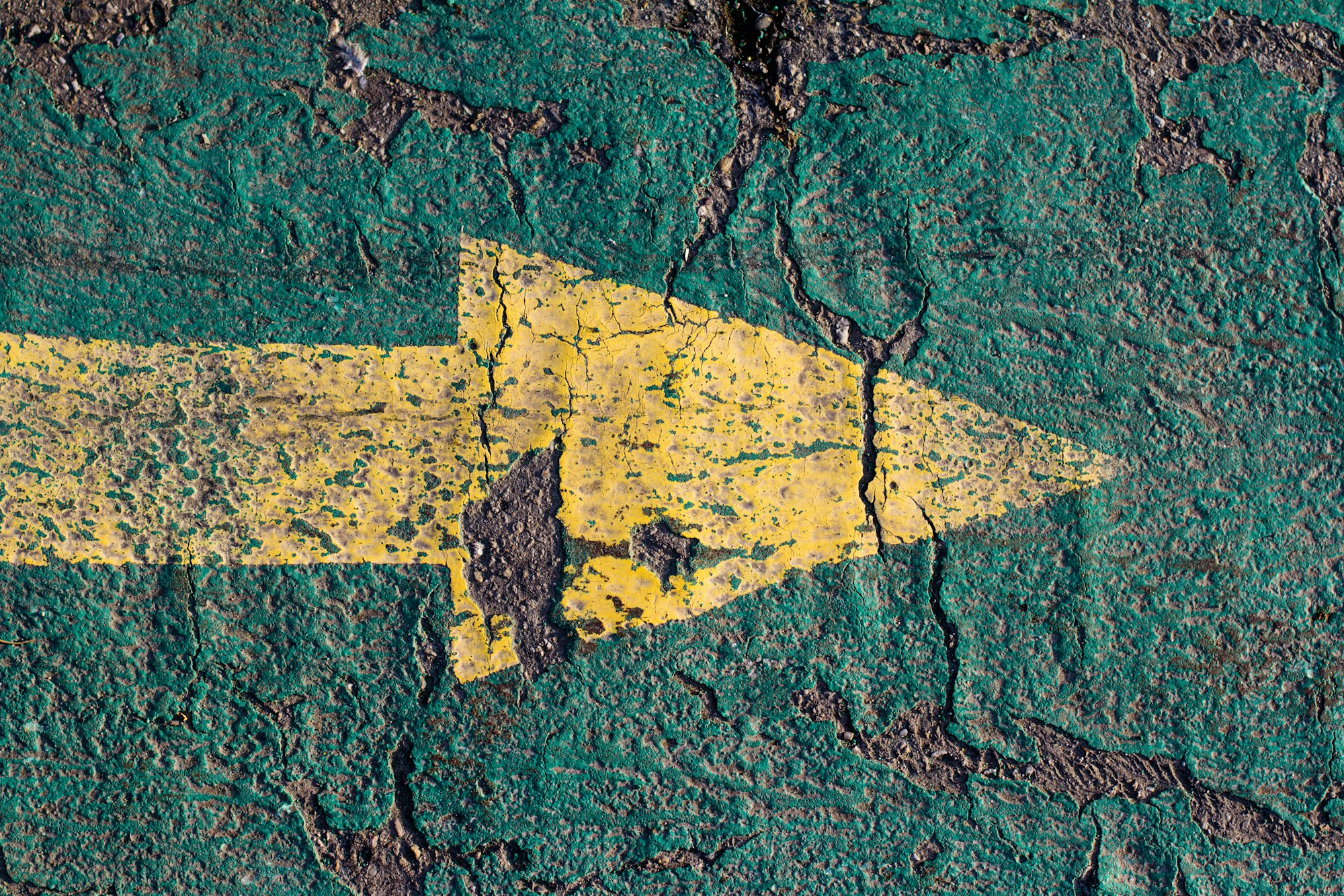 yellow arrow on blue asphalt